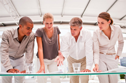 Businessmen and women standing at a table, discussing business finance